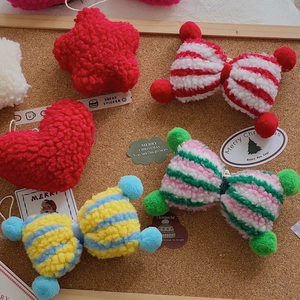 Close-up of assorted plush lamb wool Christmas bow and star charms on a cork background