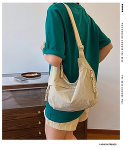 Dettaglio della borsa a tracolla beige a pieghe dallo stile casual e minimalista