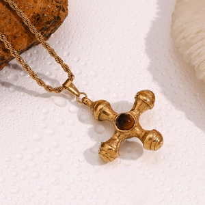Detailed macro shot of 18K gold steering wheel pendant necklace on wet white stones