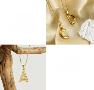 Detail of 18K gold-plated stainless steel letter pendant necklace on satin background