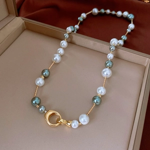 Détail d'un collier de perles rétro français avec tubes dorés et fermoir à grand anneau