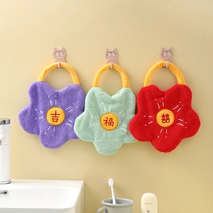 Three absorbent coral fleece flower-shaped hand towels with hanging loops in a bathroom