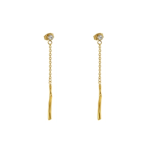 Gros plan détaillé de boucles d'oreilles dorées à pampilles avec strass et pendentifs longs