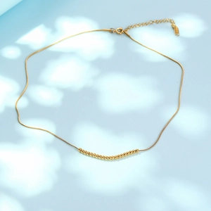 Minimalist gold beaded necklace with fine snake chain and polished metal spheres