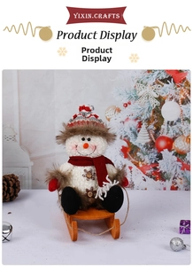 Detailed view of plush Christmas snowman doll sitting on a small wooden sled