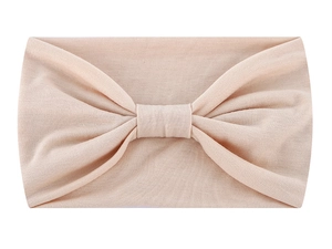 Detailed view of beige knotted headband fabric texture with soft shadows and sharp details