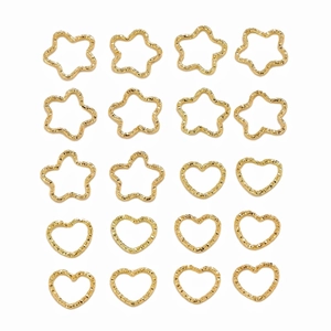 Flat lay of 20 golden star and heart shaped embossed metal hair rings on white base