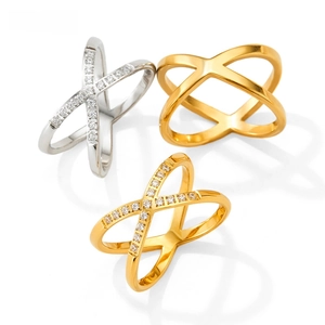 Close-up of three X-shaped criss-cross rings in gold and silver with micro-pave diamonds