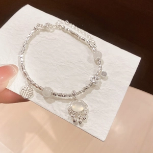 Detail of silver bead bracelet with Moonstone, Fu tag, and carved longevity lock charm