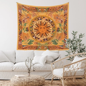 Detail of bohemian sun tapestry hanging above a white sofa in a cozy room decor