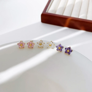 Minimalist flower stud earrings set with colored cubic zirconia petals in soft light