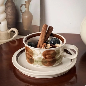 Close-up of vintage ceramic coffee cup with hand-painted floral pattern on a dark wood table