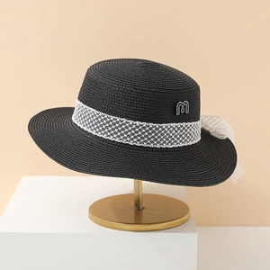 Eleganter schwarzer Strohhut mit weißem Netzband und Perlendetail auf Metallständer