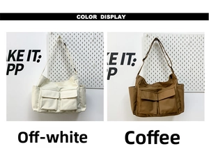Detail view of large canvas crossbody bags in beige and brown colors with flap pockets