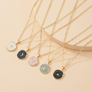 Detail of vintage heart and celestial pendants with colorful enamel on gold chains