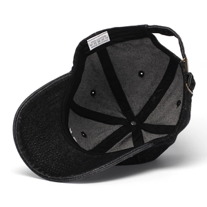 Detailed interior of black denim baseball cap showing adjustable strap and cotton label