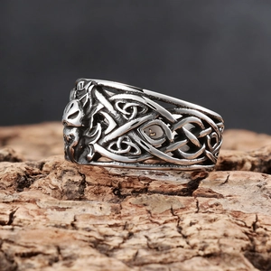 Macro shot of vintage Viking wolf head ring with Celtic knots on rustic wood background