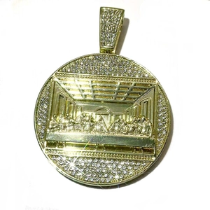 Macro shot of gold hip hop pendant with The Last Supper relief and sparkling zircon stones