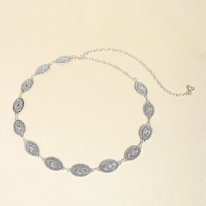 Detail view of vintage silver metal waist chain with ornate oval embossed relief links
