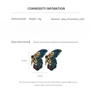 Détail des boucles d'oreilles papillon montrant la taille 6,3cm sur 4,2cm et les strass