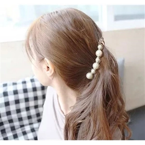 Elegant large pearl banana hair clip securing a ponytail on brunette hair