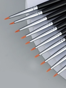 Close-up of a 10-piece fine eyeliner brush set with orange bristles and black handles