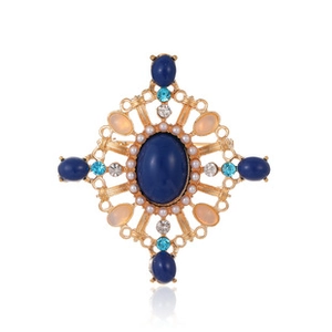 Macro shot of vintage brooch with deep blue center gemstone and colorful crystals