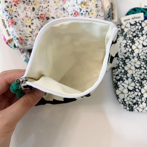 Detail of floral canvas coin purse showing zipper closure and ivory lining
