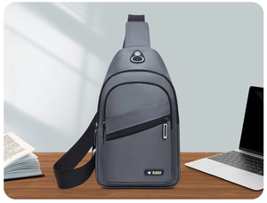 Waterproof grey oxford chest bag detail on wooden desk with adjustable shoulder strap