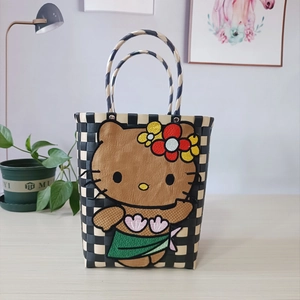 Detail of hand-woven black and white checkered bag with embroidered island-style Hello Kitty