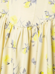 Detail of yellow floral poplin dress fabric with macro texture and pleated stitching
