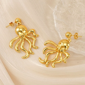 Vintage octopus earrings in 18K gold plated stainless steel on silk texture background