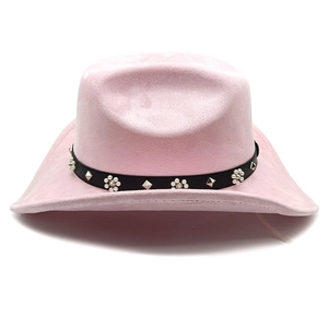 Détail d'un chapeau de cowboy rose en daim avec ceinture en cuir, clous et perles