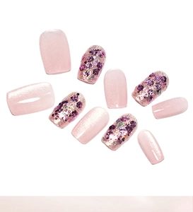 Detail of pink cat eye press-on nails with sparkling glitter sequins in short coffin shape