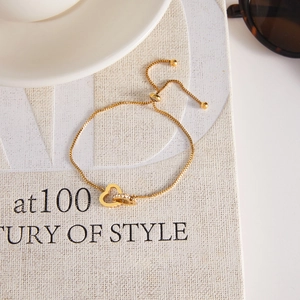 Detail of adjustable gold heart bracelet with cubic zirconia on a vintage book