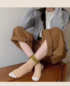 Détail de chaussettes rétro en coton à rayures orange avec revers côtelés verts