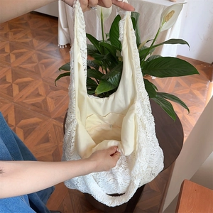 Détail du sac cabas en dentelle blanche avec doublure beige et poche zippée sécurisée