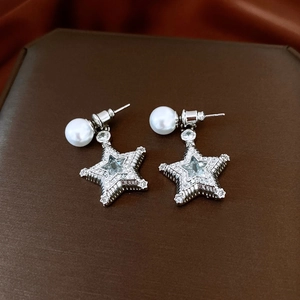 Detail of silver star earrings with pearl accents and sparkling pavé zircon stones