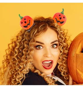 Detail of creative orange pumpkin hair clips worn by a model for Halloween party styling