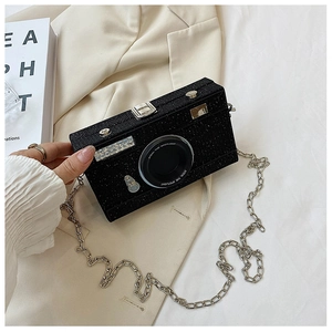 Detail of camera-shaped evening bag with silver chain strap and glittery black finish