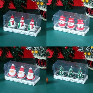 Detail view of snowman and Santa themed Christmas candles in decorative gift box packaging