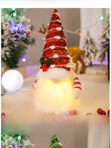 Close-up of glowing Christmas gnome with warm LED light and red knitted hat