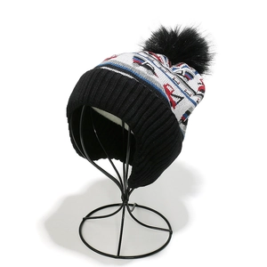 Detailed view of the thick white fleece lining inside a knitted winter hat with pom-pom
