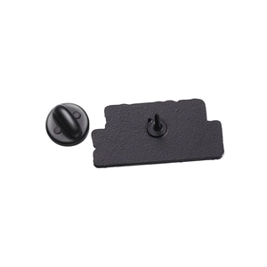 Detailed back view of a metal brooch pin featuring textured surface and black rubber clutch