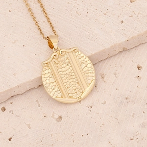 Detailed view of an 18K gold zodiac pendant with intricate dragon scale texture detail
