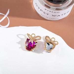 Detail of rose red and clear crystal heart pendants with gold bows on stone