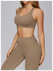 Side view of brown high-waisted yoga leggings and sports bra set in studio light