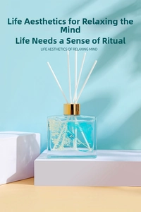 Detailed view of square 100ml glass diffuser bottle with blue oil and white botanicals