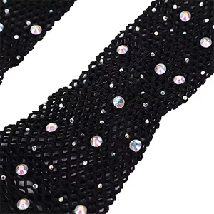 Macro detail of black fishnet gloves featuring sparkling rhinestones and mesh texture