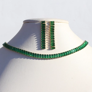Detailed view of emerald green rectangular crystal necklace and earrings set on model